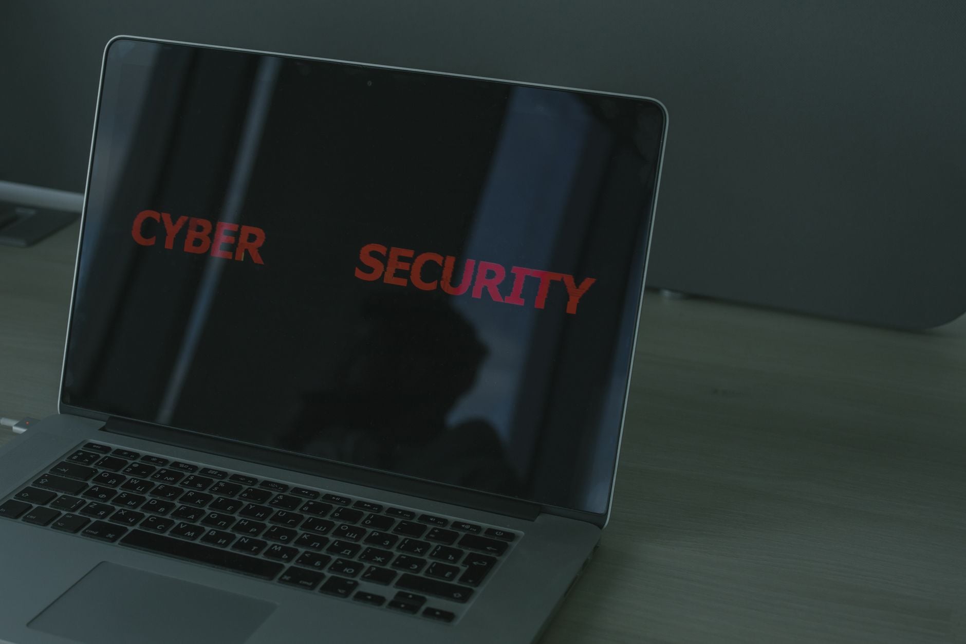Laptop z napisem CYBER SECURITY wyświetlanym na czarnym ekranie